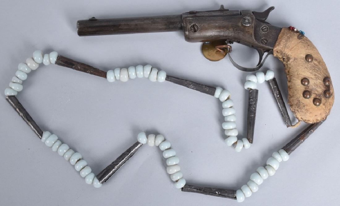 STEVENS .22 PISTOL, RAW HIDE GRIP & BEADED CHAIN: Interesting pistol with tacked on hide grip,one beaded and tin leather thong chain. Has barss collection tag. Trigger guard is not original to gun. Mechanics works. Good*