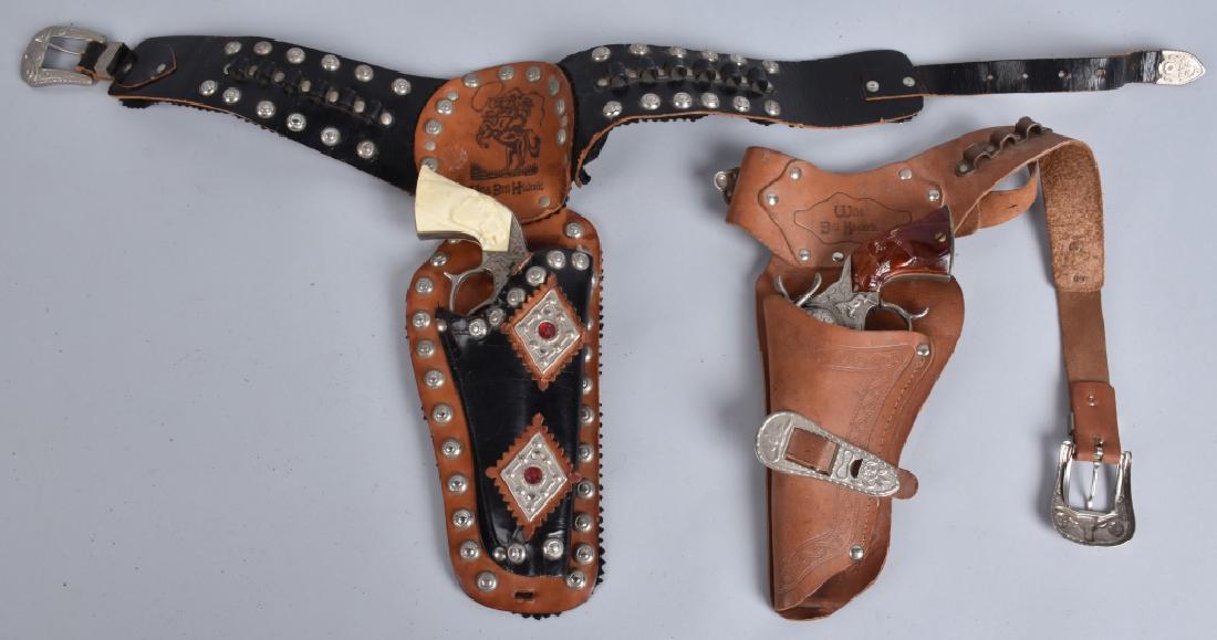 2-WILD BILL HICKOCK CAP PISTOL SETS: Largest is 9 1/2", both worked when tested. Light wear. Includes matching holsters. Excellent
