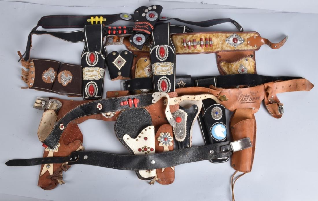 8-VINTAGE LEATHER CAP PISTOL HOLSTERS & MORE: Nice grouping with double and single sets. Also included are and extra belt and some leather cuffs. Condition varies. Overall Very Good