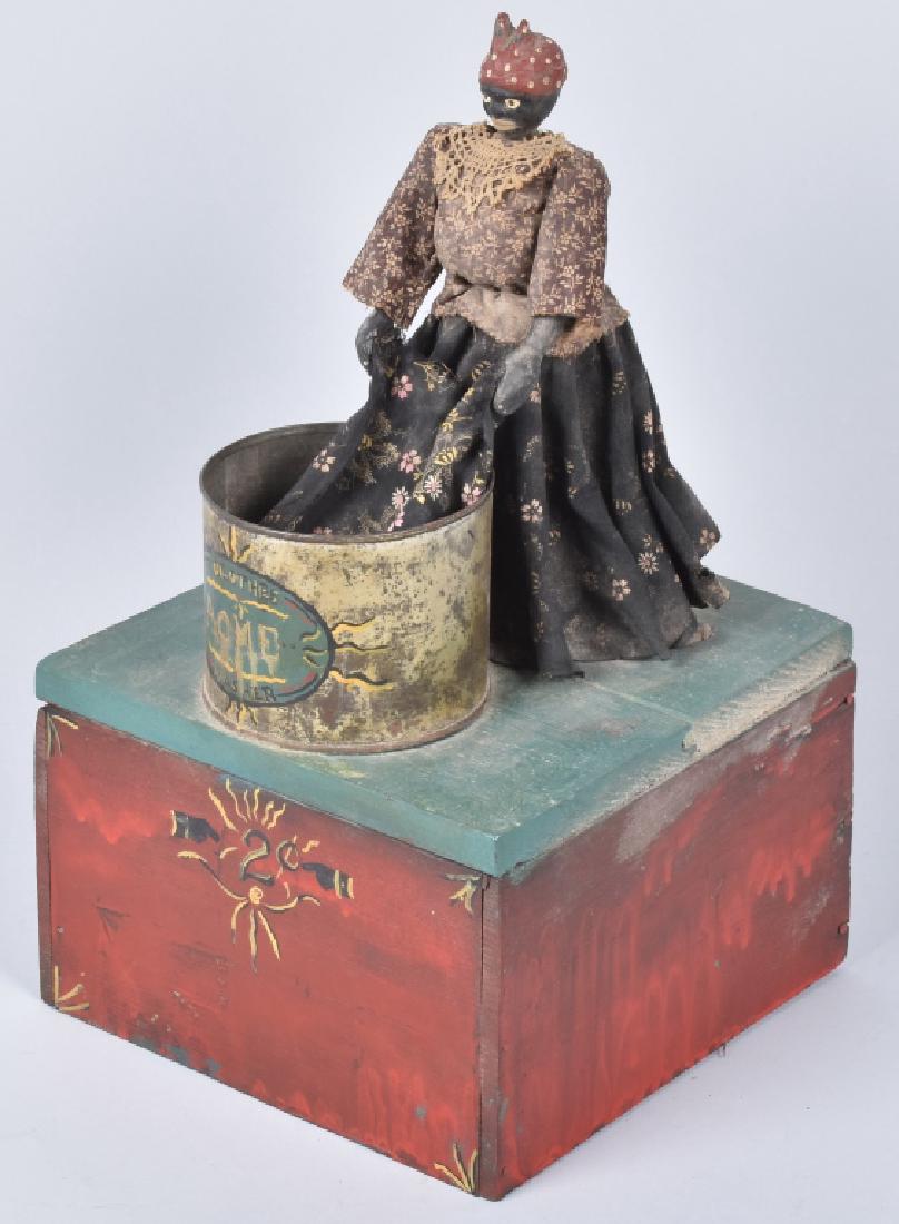 FOLK ART BLACK MAMMY ACME CLOTHES WASHER: Folk Art Mammy figure washing clothes set on wood base. Steel tun marked Acme Clothes Washer. Age unknown. 16" Excellent