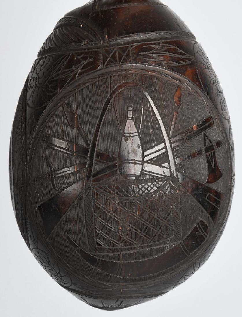 Turn of the Century SCRIMSHAW COCONUT w/ WEAPONS: Late 1800s Scrimshaw Coconut with Guns, Swords, and Spears on one side. American Shield with British and other Flag on second side. And Basket of Flowers on third side. Plus Sun, Sea Shell, and other 