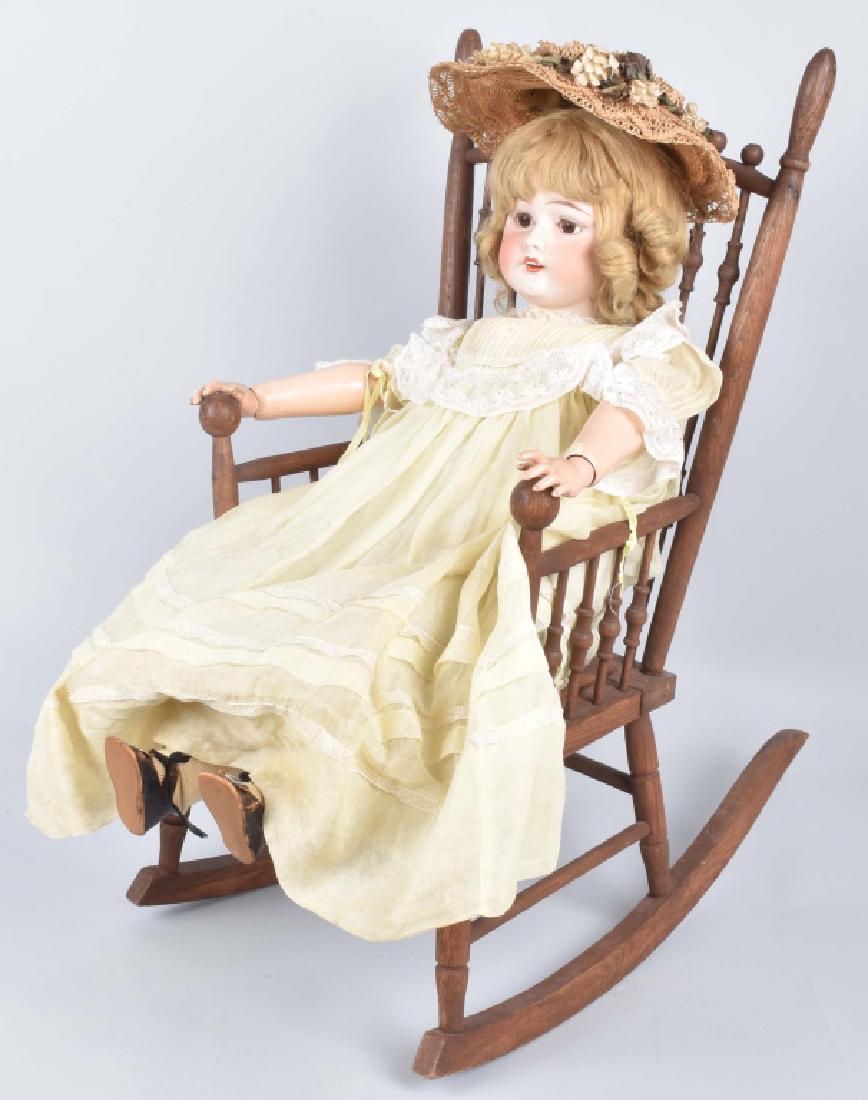 FULPER AMERICAN BISQUE DOLL & ROCKER: Doll is about 28" and has fixed eyes. Manufactured between 1918-1927. Wig is glued on, jointed composition body has some touch up and wear. Nicely dressed. Includes vintage rocker for display. Very Go