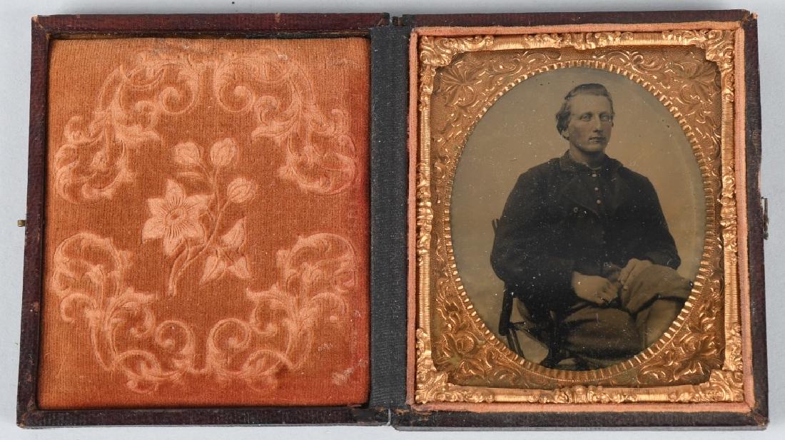 CIVIL WAR 1/6 TINTYPE SOLDIER SITTING - CAMP CHAIR: 1/6th plate tintype of a union soldier sitting on a folding camp chair. Soldier is pictured wearing a vest and 4 button sack coat. Image housed in a full case. excellent.