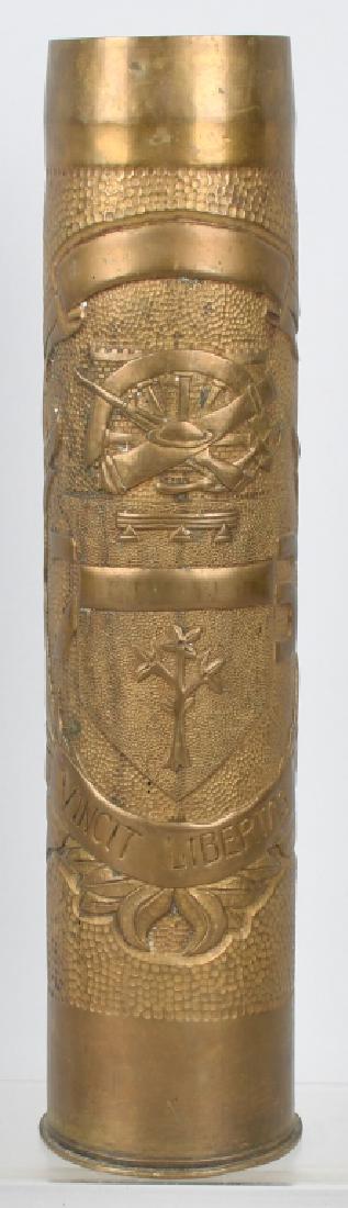 WWI GERMAN POW MADE TRENCH ART 75MM SHELL: 75mm shell featuring crossed cannon & rifle over a unit insignia and the words Vincit Libertas. Engraved on the other side is "Made by prisoner of war Herm. Meyer Feb 13, 1919 IS-SUR-TILLE". Shell sta