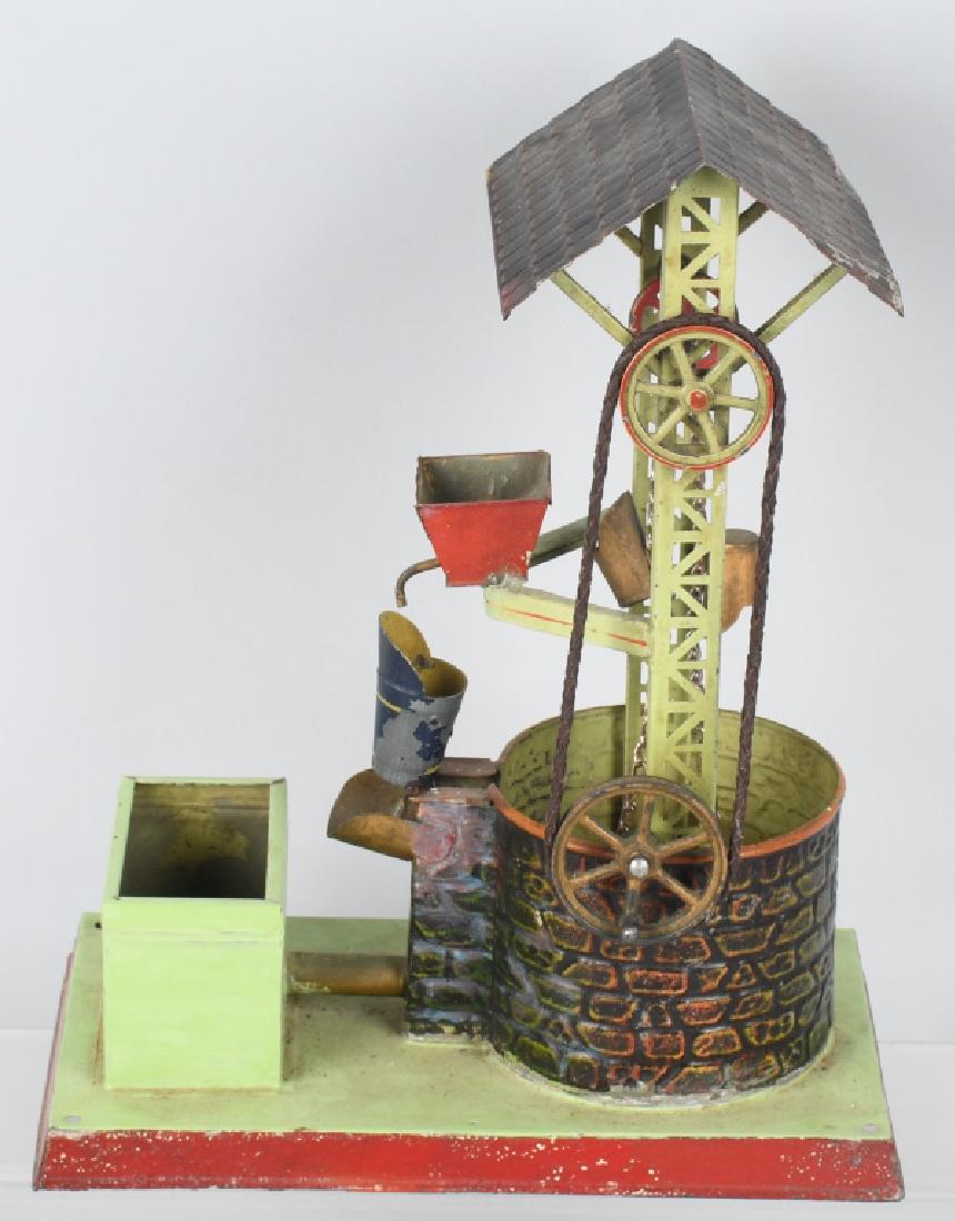 GERMAN DOLL & CO. WATER WELL STEAM TOY: Early soldered tin and hand painted steam toy accessory made by the famous German steam engine toy co, Doll. Large size at 12" high with a base of 9" by 5 1/2".Original paint is nice, and chain to buc