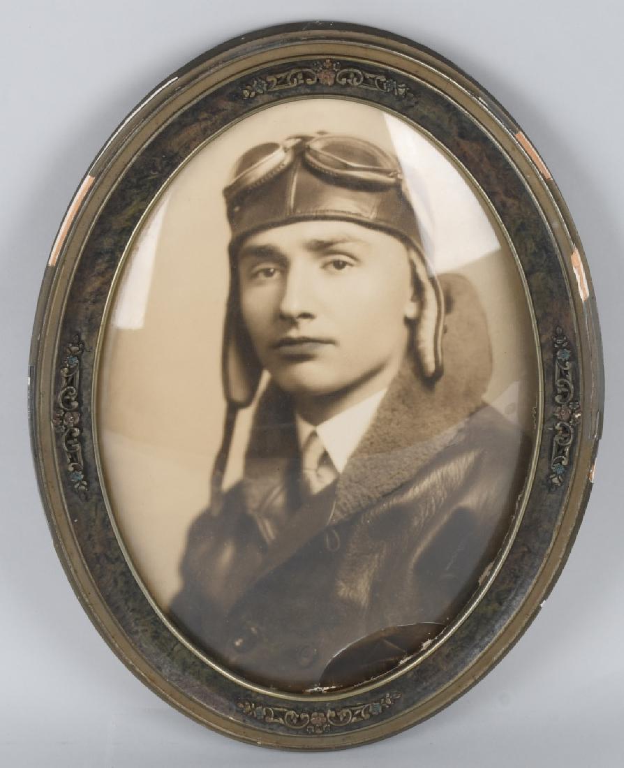 WWI ERA FRAMED IDED U.S. PILOT PHOTOGRAPH: World War One era Photograph in a large oval frame featuring a pilot wearing his flight helmet and goggles. A tag on the back of this image identifies the pilot as "William Sigmund 22 years old". Fram