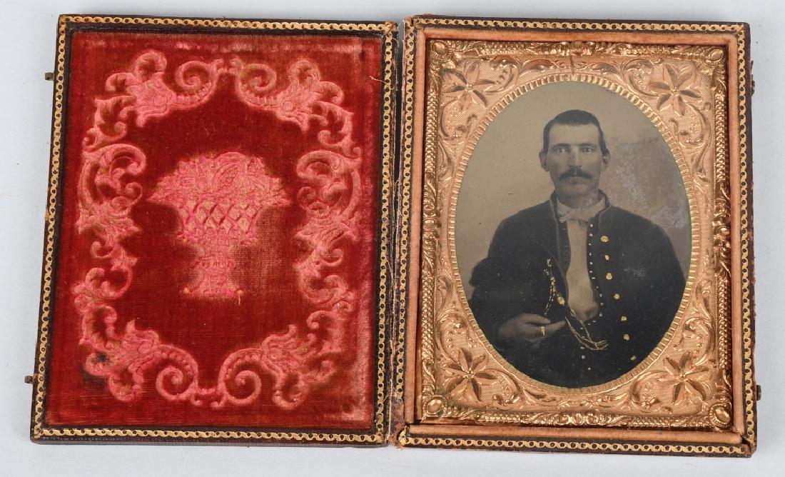 CIVIL WAR 1/4 TINTYPE SOLDIER W PLUMED SLOUCH HAT: 1/4th plate tintype of a Union soldier holding a plumed slouch hat with beautifully tinted hat cord. Image is housed in a full leatherette case that is separated at the spine. excellent.