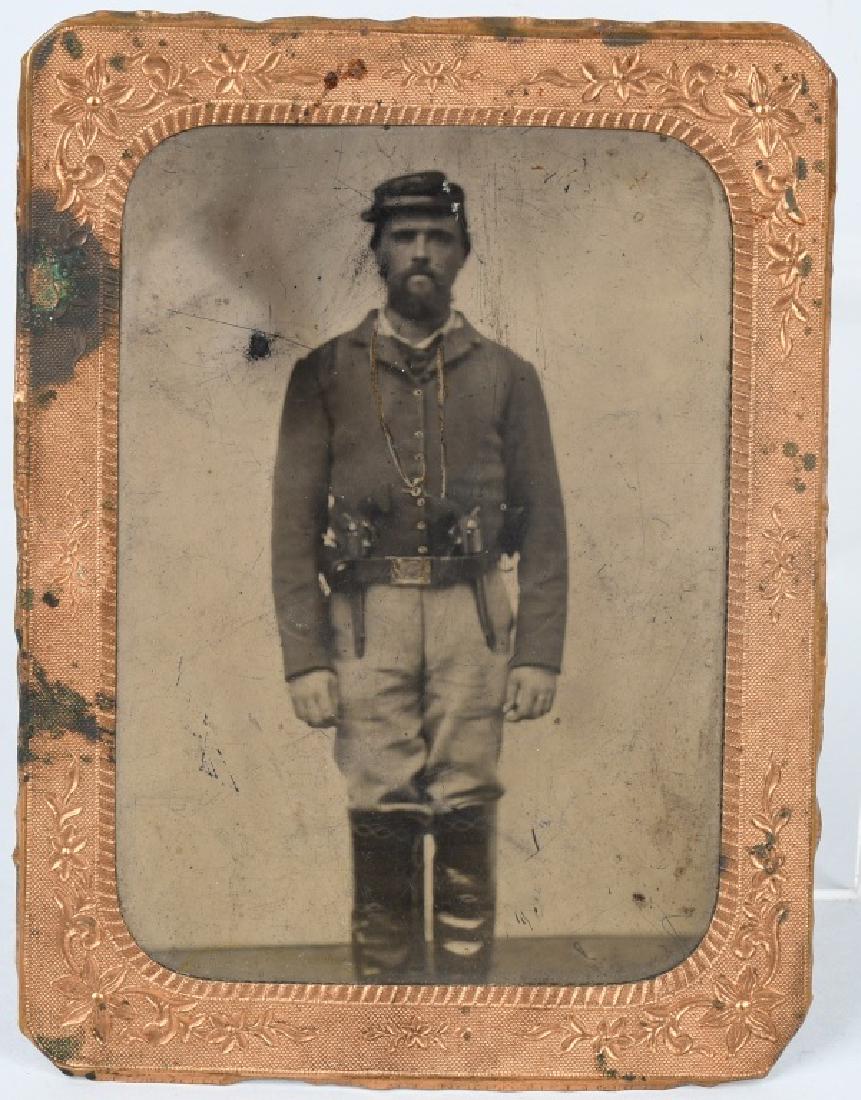 CIVIL WAR 1/4.TINTYPE UNION CAV SOLDIER 2 PISTOLS: 1/4 plate tintype of a Union Cavalry soldier wearing a shell jacket. Two large pistols are tucked into his belt . Image is housed in a mat. very good - excellent.