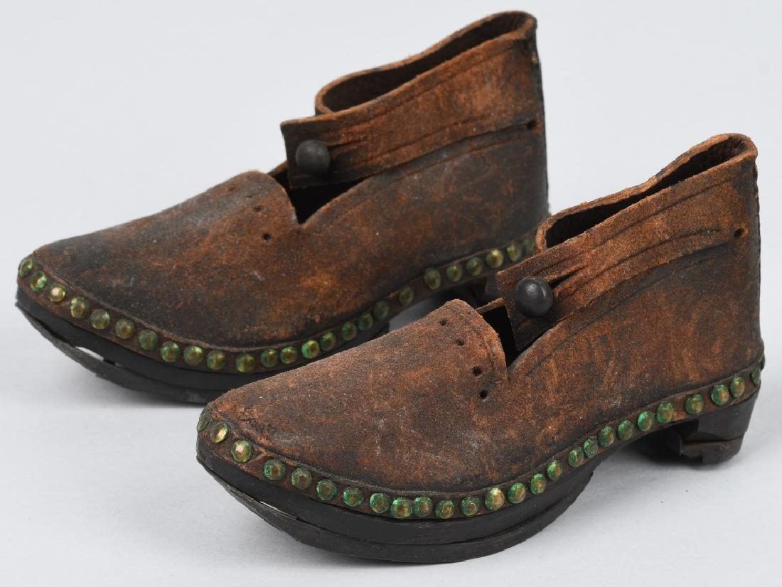 19th CENTURY WOOD SOLE LEATHER SHOES, IRON BOUND: Great pair of Salesman Sample or child's shoes. Wood soles with iron bands on sole and heel. Cut square nails are used to hold the bands on. Body is leather with a button enclosure. Brass tacks attach
