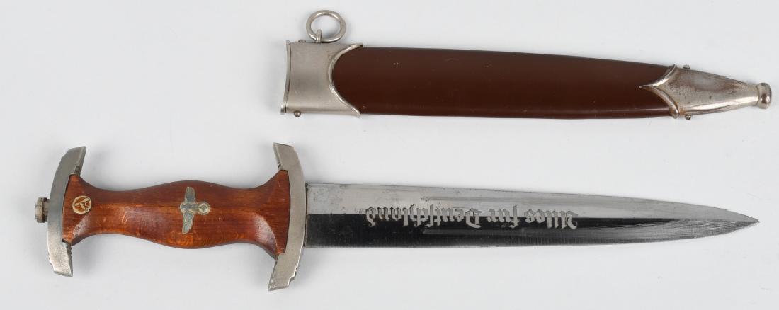 WWII NAZI GERMAN SA DAGGER BY WKC WITH SCABBARD: SA dagger with a 22cm long double-edged drop-forged and nickel-silver plated blade in its original scabbard. The dagger has a cast pommel and tang nut. Its contoured wooden grip has inlaid to its obve