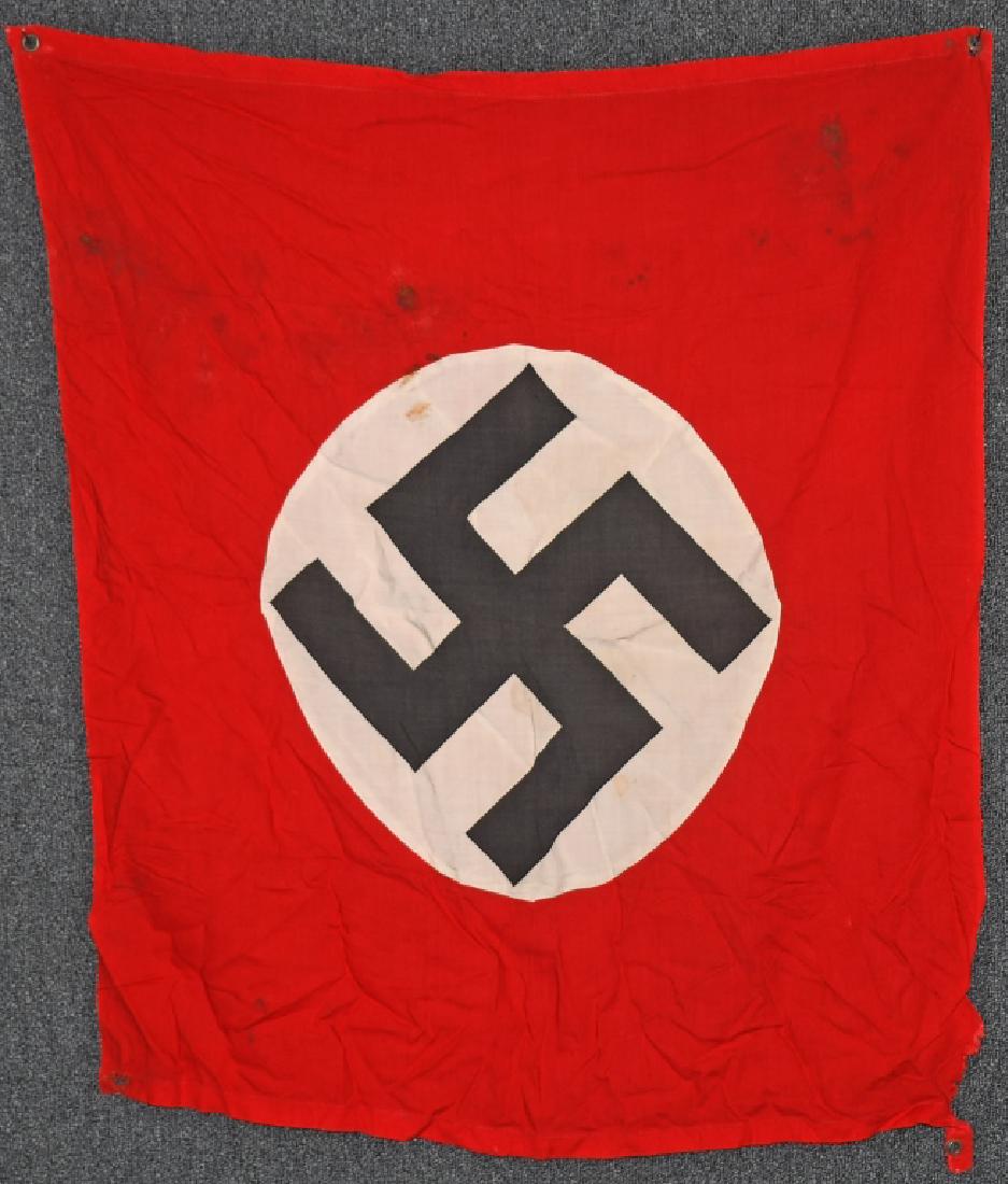 WWII NAZI GERMAN VEHICLE ID FLAG: A smaller sized on wool construction single sided banner approximately 31 x 35 inches. Some stains with a tear to one corner. Flag features a white sewn disk with a printed mobile swastika to the cent