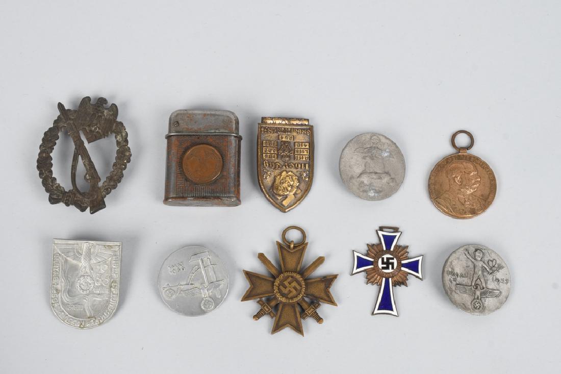 WWII NAZI GERMAN MEDALS & TINNIE LOT OF 10: Lot consist of Infantry Assault Badge (Missing Pin), 5 Party tinnies all still retaining their original pins, WW1 Austrian service medal missing ribbon, lighter with Nazi coins attached, Mothers Cross