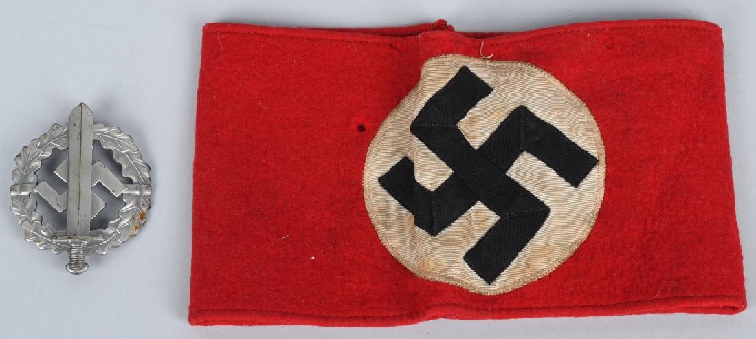 WWII NAZI GERMAN PARTY ARMBAND & SA SPORTS BADGE: WWII multi piece wool construction NSDAP armband having an approximately 9cm diameter white disk with a black multi piece mobile swastika to the center. Armband still retains a portion of the original