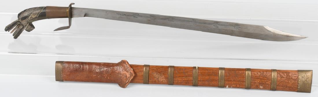 MORO PHILIPPINE KAMPILAN SWORD: Traditional Moro / Philippines sword with figural alligator with open jaws and flailing tongue and sharp teeth on the handle. Has leather frog, rings of stamped brass, engraving on the blade and carvi