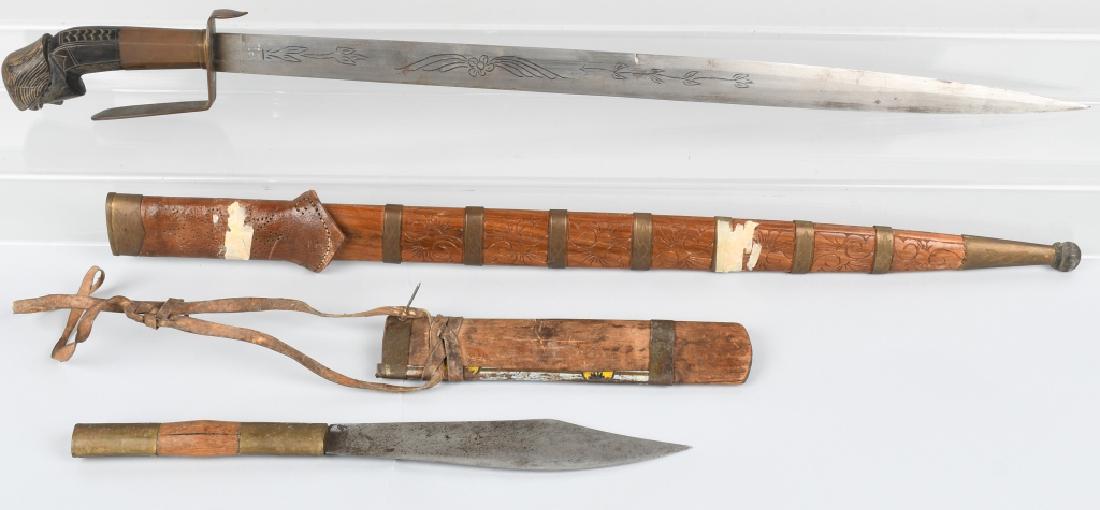 PHILIPPINE BARONG KNIFE AND SWORD: Two traditional fighting and hunting blades from the Philippines. Barong style sword with straight pointed blade, marked "P.I." on the blade, engraved with floral pattern, has brass guard and figural