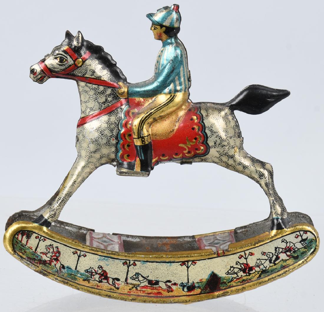 GERMAN JOCKEY on ROCKING HORSE tin PENNY TOY: Ver nice all original jockey on rocking horse German tin penny toy. Great colors and graphics. 3 3/4" by 3 1/2", Excellent