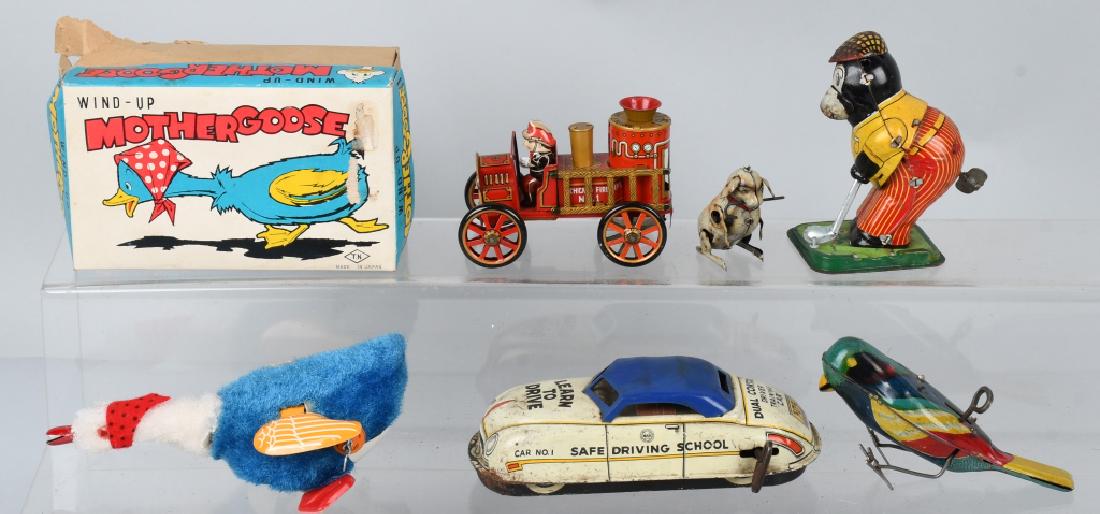 VINTAGE mechanical tin TOY LOT, MARX and MORE: Lot includes a Marx 6 1/2" tin Learn to drive car, a TN Japan 7" Mother Goose with box, a 5 1/4" tin windup bird, TPS Japan bear golfer, a Japan 4" friction fire engine, and a Japan 2 1/4" windup dog.