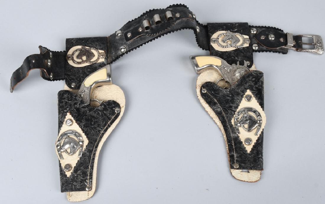 GENE AUTRY CAP GUN SET w/ HOLSTER: Pair of Gene Autry Cap Guns. Both original one gun works but doesn't spring back. Wityh leather Holster. 8" Very Good-Excellent