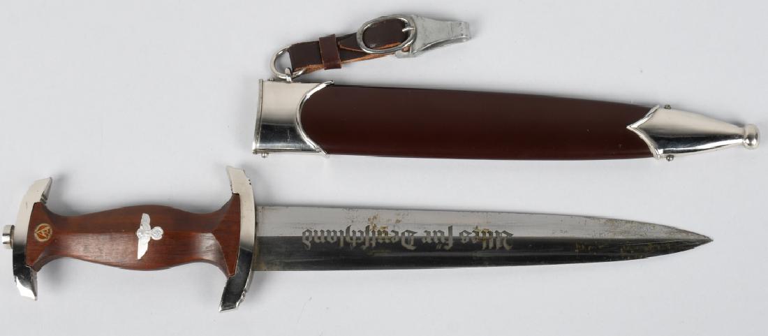 WWII NAZI GERMAN SA M33 DAGGER M7/85 MINT: SA dagger with a 22cm long double-edged drop-forged nickel-silver plated blade in its original scabbard. The dagger has a cast pommel and tang nut. Its contoured wooden grip has inlaid to its obverse 