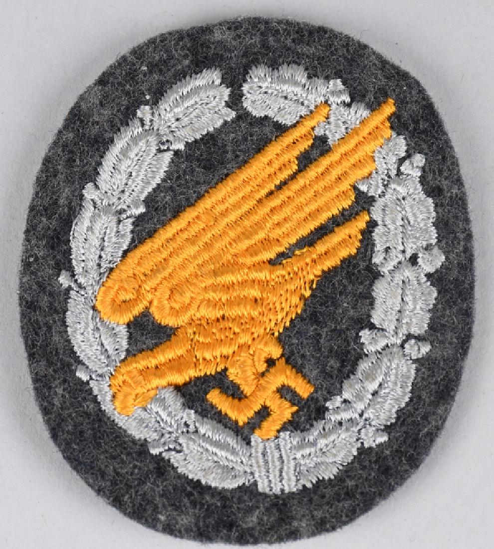 WWII NAZI LUFTWAFFE PARATROOPER'S BADGE IN CLOTH: The badge consists of a roughly 70mm tall, 60mm wide Luftwaffe blue/gray wool construction vertically oval base which features a machine embroidered stylized "diving" eagle clutching a swastika in it�