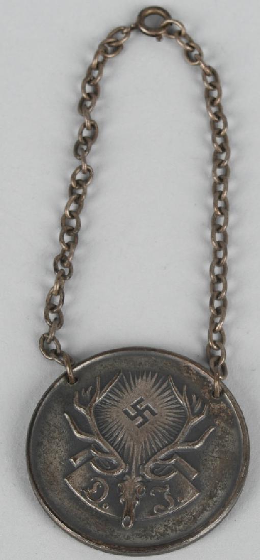 WWII NAZI DEUTSCHE JAGERSCHAFT DJ 1938 AWARD: A 30mm badge in the form of a deer’s skull with antlers between which is a mobile swastika with rays radiating out from it. Flanking the skull to the base is "D" and "J," for "Deutsche Jagerschaft" 