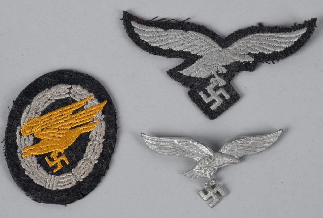 WWII NAZI GERMAN LUFTWAFFE PARATROOPER BADGE LOT: Lot of three Luftwaffe items including a Fallschirmjäger badge in cloth. The badge consists of a roughly 70mm tall, 60mm wide Luftwaffe blue/grey wool construction vertically oval base which features