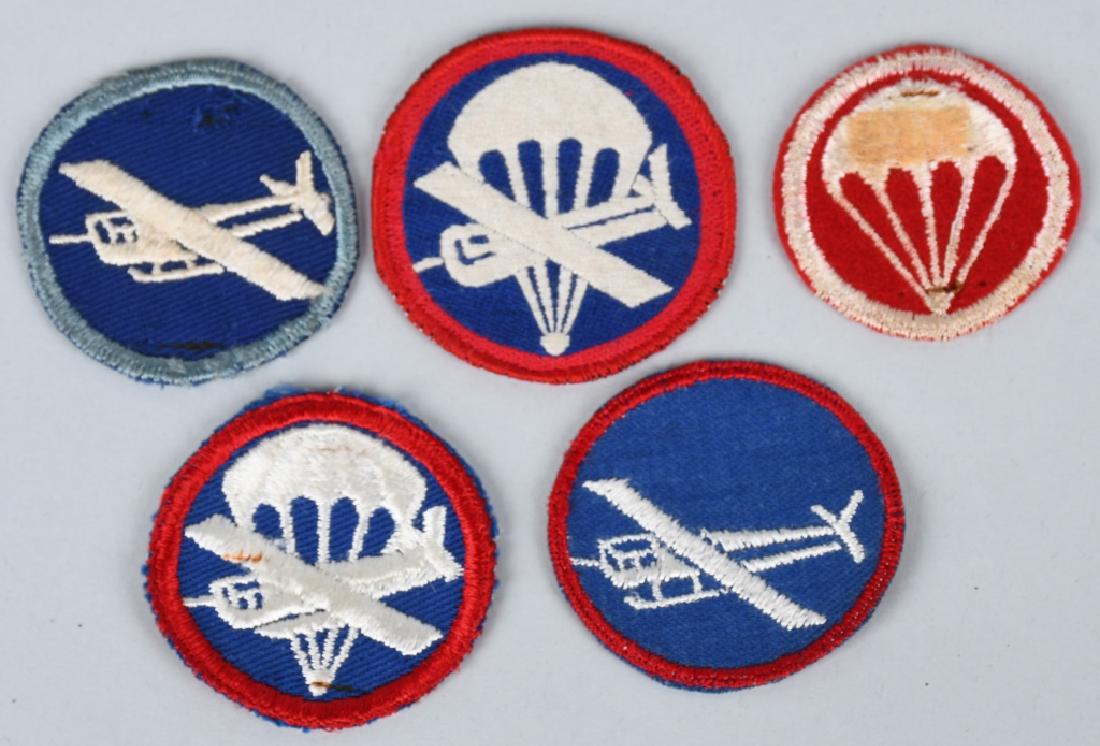 WWII LOT OF 5 AIRBORNE CAP BADGES 1 THEATER MADE: WWII issued infantry and artillery paratrooper / glider cap badges lot of 5 including one theater made. Patch does not react to Uv light and are in near mint condition.
