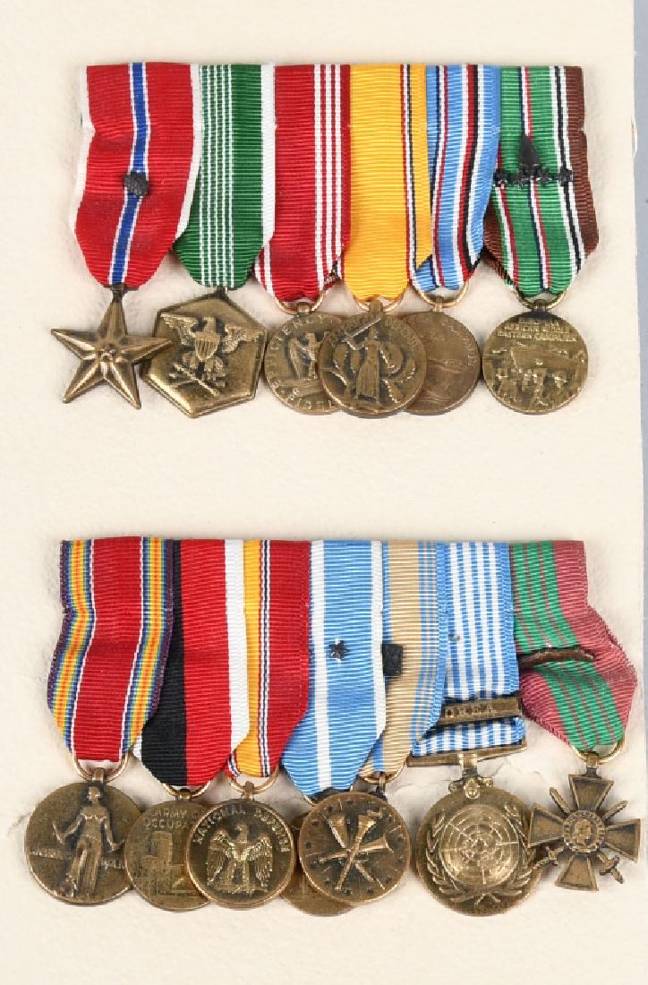 WWII and KOREAN WAR MEDALS FROM A D-DAY VETERAN: Set of 13 miniature medals, professionally mounted onto two bars. Medals denote awards of the Bronze Star (with Oak Leaf Cluster indicating two awards), Army Commendation Medal, and Croix De Guerre. T
