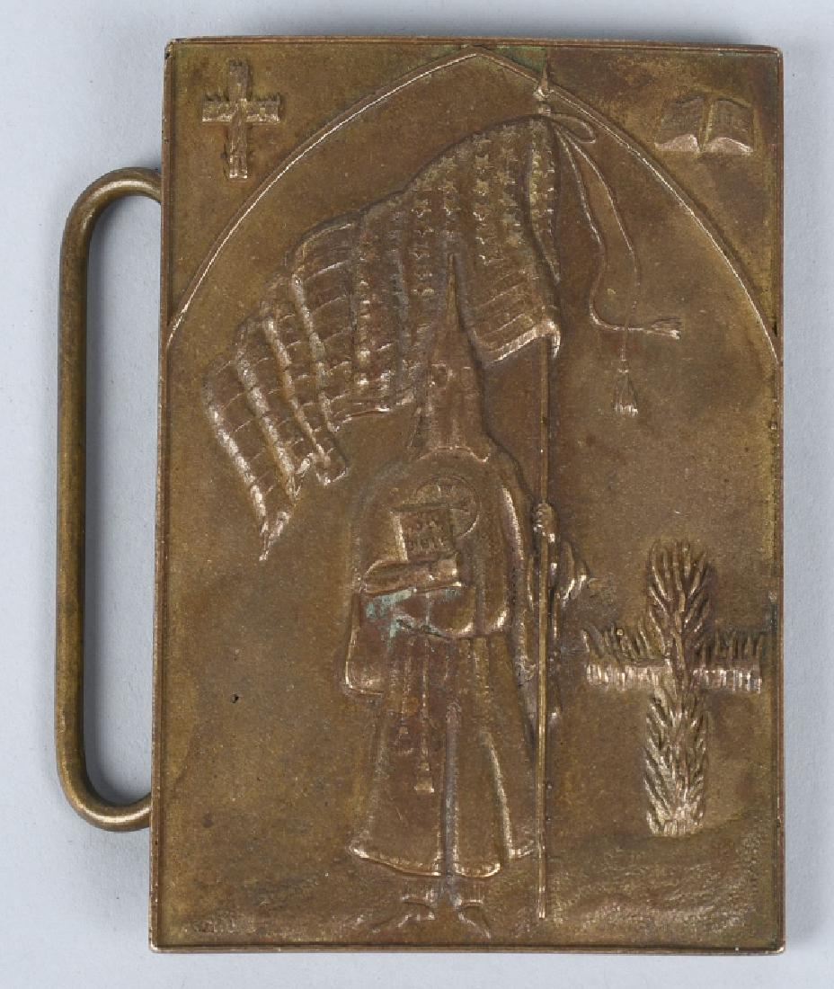 KKK KU KLUX KLAN BELT BUCKLE MARKED TIFFANY: Brass belt buckle with a robed Klansman, a cross, a bible, an American flag, and a burning cross on the front. Back is marked "Salem Mass. Witch" with a flying witch on a broomstick, "Tiffany & Co." a