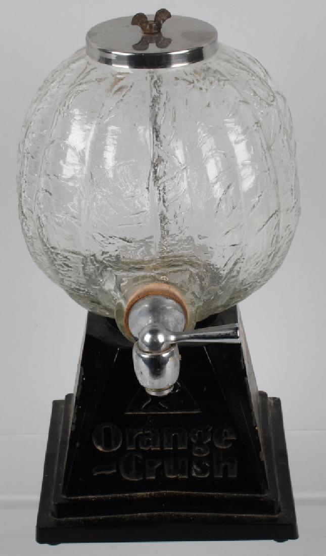 VINTAGE ORANGE CRUSH SYRUP DISPENSER: Original Soda Fountain Orange Crush Syrup Dispenser. Black cast metal base with glass orange shaped bottle. Complete with top. Base is original with good paint and decals. 13 1/2" Very Good-Excellent