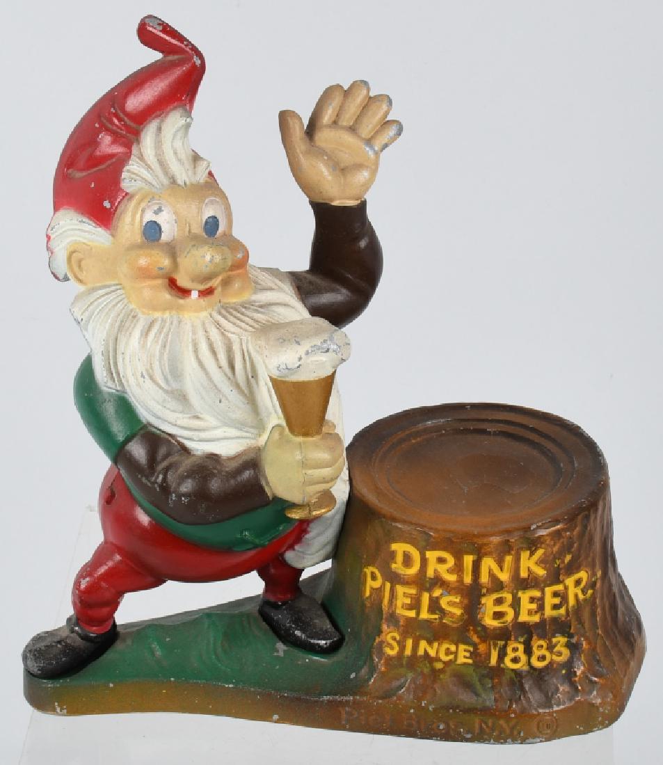 PIELS BEER METAL FIGURAL STORE DISPLAY: A beautiful metal diecast back bar single elf statue from Piel Brothers Brewing, Brooklyn, NY. Figure is in nice original condition with some paint loss. Brewed in Brooklyn, NY. 9 1/2" by 8". Very Goo