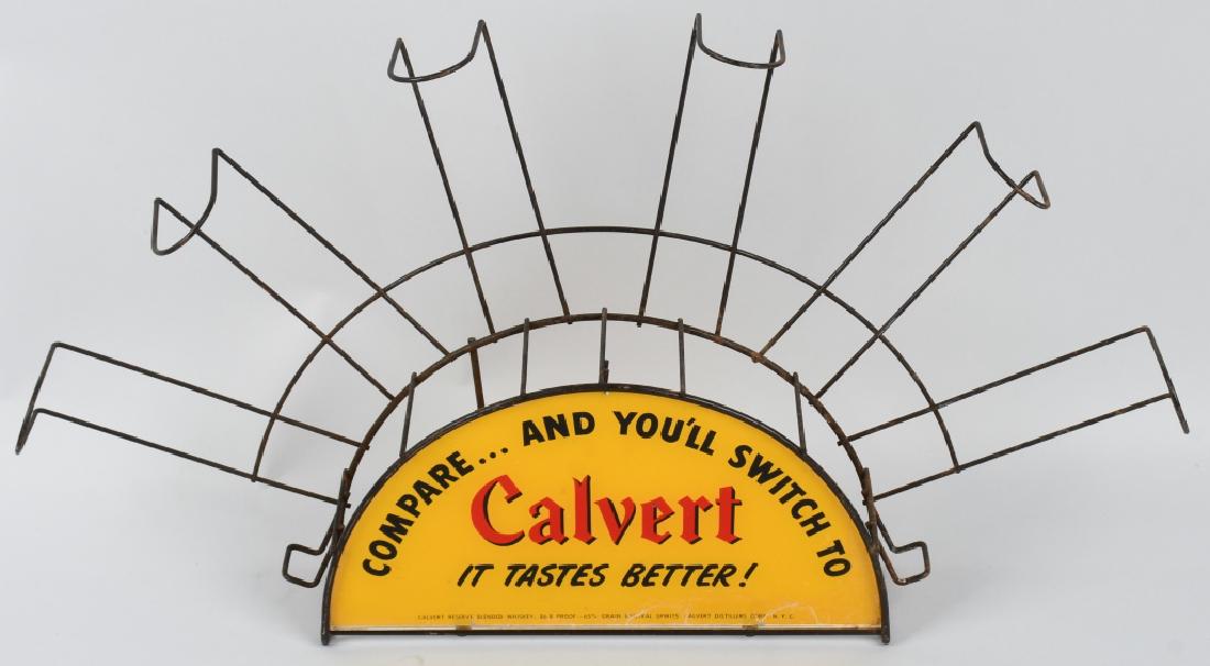 LORD CALVERT WHISKEY GLASS & WIRE STORE DISPLAY: Bottle rack holds 6 bottles and has a reverse glass paint Calvert sign. Measures 25" by 14". Excellent