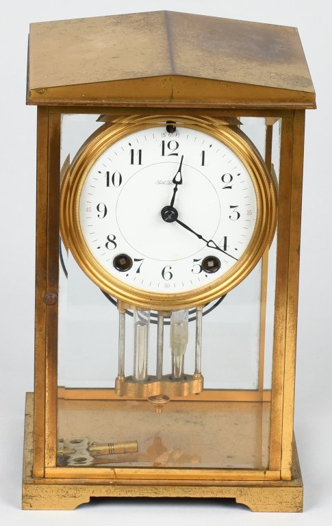 SETH THOMAS BRASS & GLASS MANTLE CLOCK: Clock case is brass with beveled glass throughout. The face is porcelain and is marked Seth Thomas. The brass works are marked ST 48N. Pendulum has tape repair. 9" by 6" by 4". Very Good