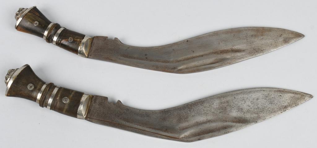 PAIR OF EARLY 20th C NEPALESE GURKHA KUKRI KNIVES: Pair of early 20th Century Nepalese Gurkha Kukri knives. Both have lion faces on the pommel and both have hand tooled markings on the blades. 14.25" overall length for both, but one has a slightly thi