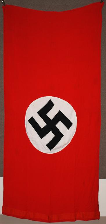 WWII NAZI GERMAN NSDAP NATIONAL WALL BANNER: Multi-piece, double sided, cotton construction banner approximately 56 x 111 inches. To both its red fields are sewn white disks, with a printed mobile swastikas in black. Tunnel loop to one end. Prob