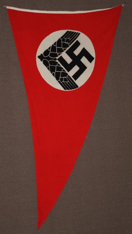 WWII NAZI GERMAN FEMALE RADwJ PENNANT: A double sided, printed, red pennant measuring approximately 47 x 78 inches featuring a 59cm diameter badge. The pennant is unmarked and is in very good condition with no tearing. The female version o