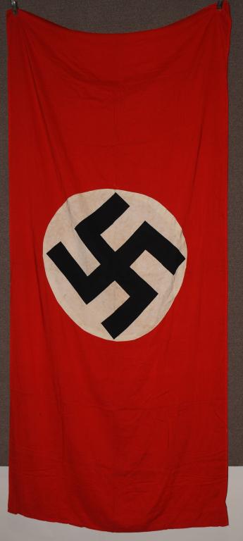 WWII NAZI GERMAN NSDAP WALL FLAG: Roughly 98 x 46 inches double sided two piece, printed cotton and rayon construction national flag features a red cotton base field with a central 31 inches diameter, white circular disc with a canted