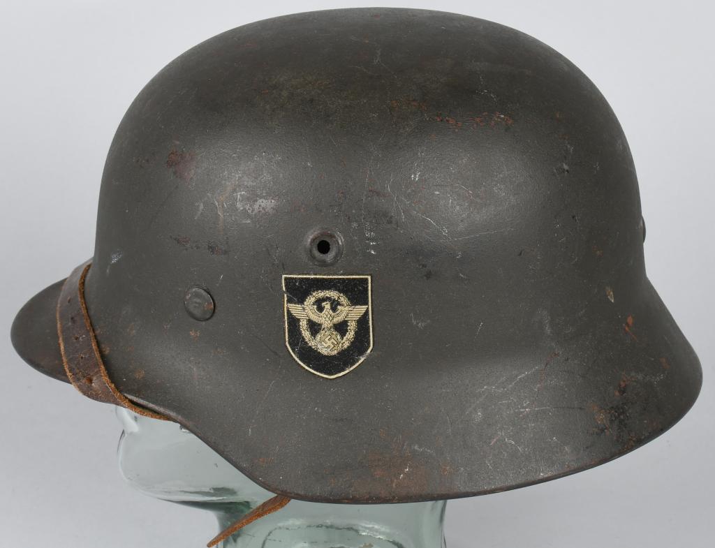 WWII NAZI GERMAN M40 DOUBLE DECAL POLIZEI HELMET: The stamped sheet steel construction helmet M40 retains about 90% of it’s original age and usage darkened, slightly rough textured field-grey paint. The helmet has the fourth and final pattern polic