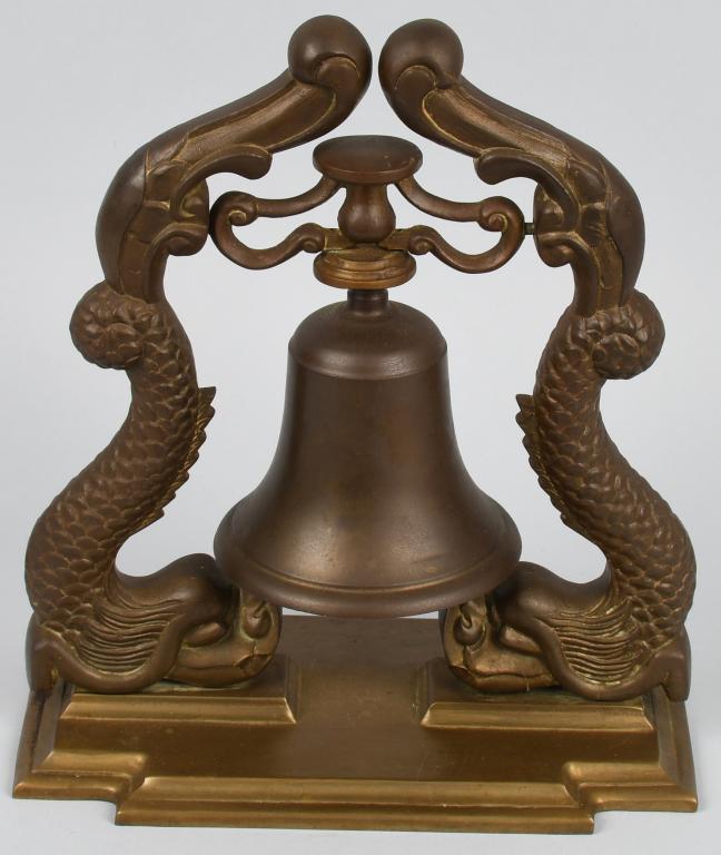 US NAVY SUBMARINE OFFICER'S WARDROOM BELL: Vietnam era US Navy Officer's wardroom bell. Brass bell on base with stylized US Navy Submarine Warfare insignia "dolphins" / dragons on either side of the bell and a flat base. Measures approximately