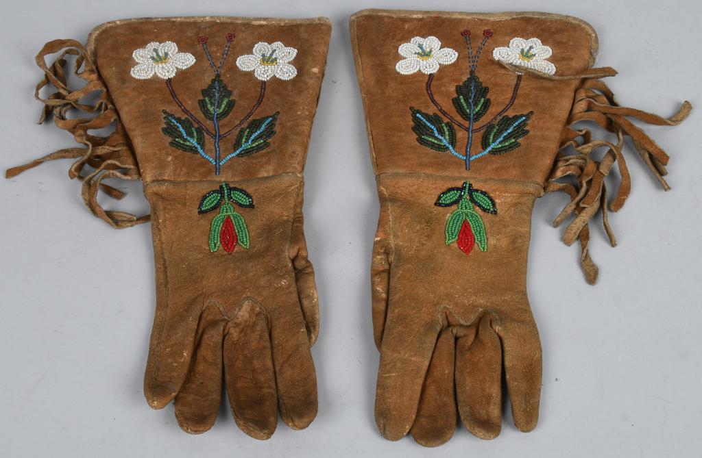 NATIVE AMERICAN BEADED LEATHER GAUNTLETS: Nice pair of beaded leather gauntlets. Each has a matching bead design, leather fringe and cloth liner. general wear and soiling, some small tears to liner. 11" Very Good.