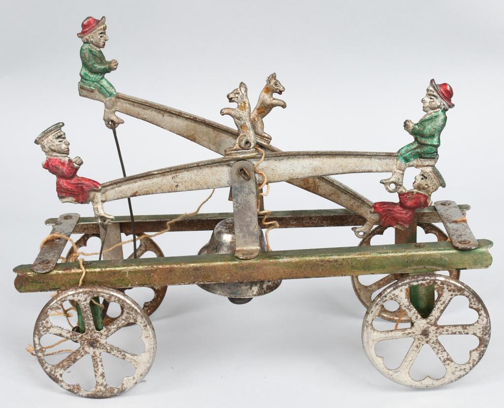 WATROUS CAST IRON DOUBLE SEE SAW BELL TOY: Excellent original Watrous Double See Saw Bell Toy. Unusual version with Boys, Girls, and Dogs on the Sea Saws. Still has nice original finish. No breaks or issues. 10" Excellent