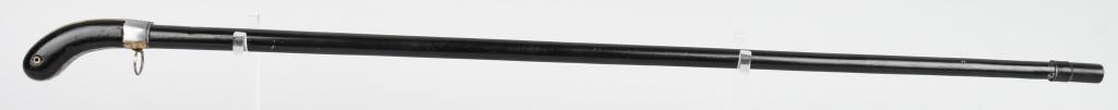 UNUSUAL AND UNMARKED PERCUSSION CANE GUN: On this example, the tip comes off and a round is loaded into staff , tamping it home with the wooden doll that is inside. Under the handle, there is a pull that once pulled, exposes a nipple to be ca