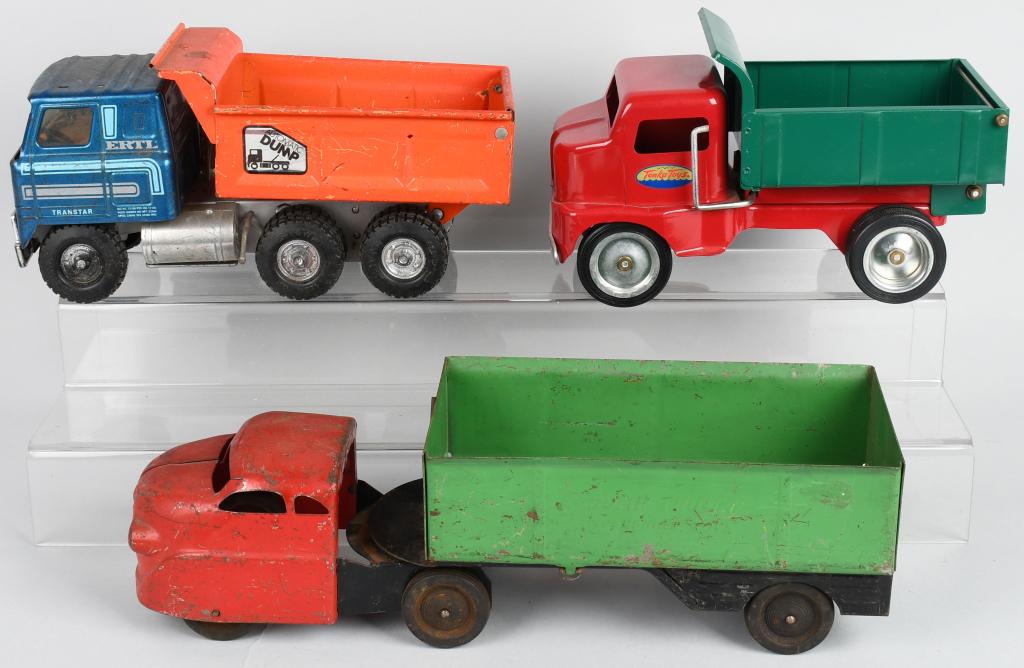 3- TOY TRUCKS, WYANDOTTE, ERTL & MORE: Lot includes an all original Wyandotte side dump truck, a original Ertl Dump truck, and a reproduction Tonka dump truck. Largest is 17". The Wyandotte and Ertl are Very Good. The Tonka is Excellent