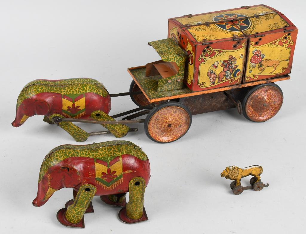 LINDSTROM TIN WINDUP CIRCUS WAGON & ELEPHANT: Original tin windup Elephant pulling Circus Wagon. Has cages, lion, and windup elephant. Has some wear and loose parts. Windup works. 16" Very Good