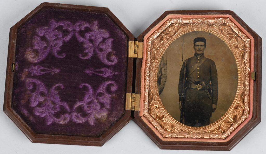 CIVIL WAR DOUBLE ARMED TINTYPE w GUTTA PERCHA CASE: Fantastic Civil War double armed image of a federal soldier carrying Springfield model 1842 rifle with bayonet attached. Wearing a 9 button Federal issue frock coat with eagle buttons and leather belt