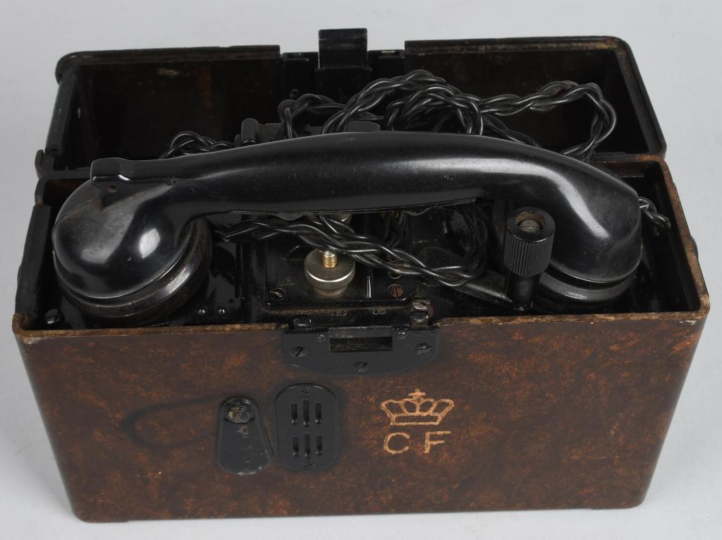 WWII NAZI GERMAN ARMY F33 FIELD TELEPHONE 1940 Dt: The roughly, 22cm tall, 28cm wide, 9cm thick, molded mottled brown Bakelite construction telephone housing case has a fold back top lid with a screwed on, magnetic sheet metal, horizontal bar hinge to
