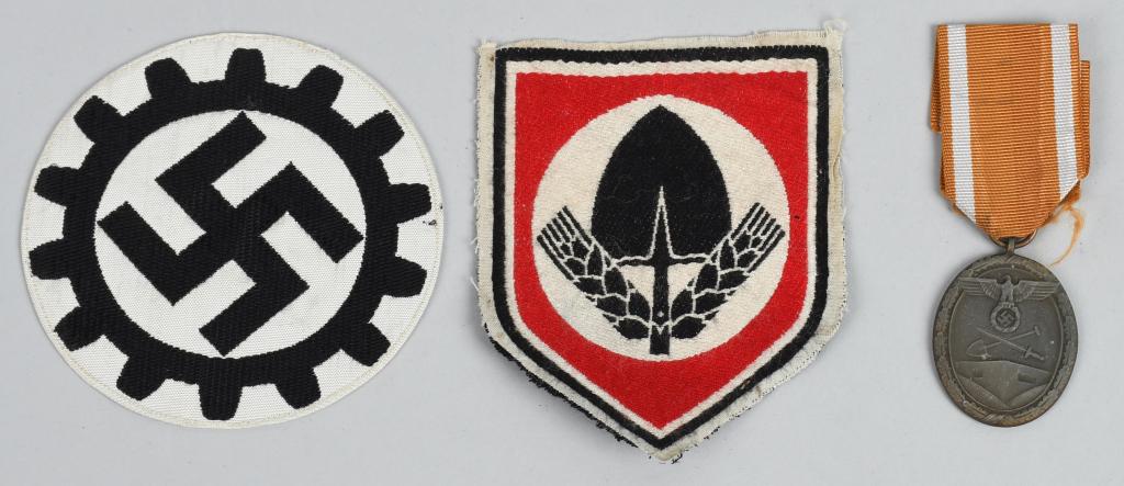 WWII NAZI GERMAN INSIGNIA LOT RAD DAF WEST WALL: Lot of WWII Nazi German insignia including a DAF emblem of a mobile swastika within a fourteen-toothed cog gear. The reverse has a paper A RZM tag. Second is a large roughly 4 1/4 tall X 3 1/2 wide ma