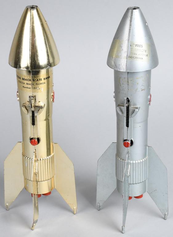 2- Rocket Mechanical Banks w/ Advertising: One gold and one silver Rocket Mechanical Banks. Both with Bank advertising. Silver advertising partial gone. 11 1/2" Excellent