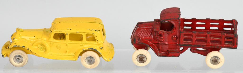 2- 1920'S cast iron AUTO TOYS, A. C. WILLIAMS: Lot includes a 5" yellow dual side mount sedan, along with a 4 3/4" Mack stake truck. Both toys are all original with no cracks or breaks. Excellent