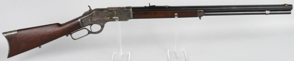 FINE CASE COLOR WICHESTER 1ST MODEL 1873 RIFLE: Serial #9560. Barrel length 24". Caliber 44-40. Made in 1875. Second year production with thumb print dust cover. Features full octagon barrel, full magazine, semi-buckhorn rear sight, German silver k